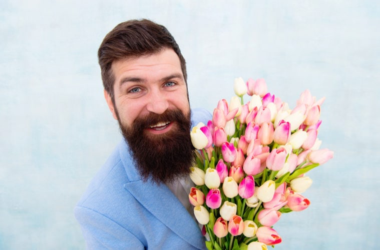 Top 5 most annoying romantic gestures guys do: bearder man bringing a bouquet of tulips